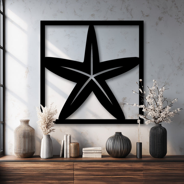This unique metal wall art, a black starfish frame, highlights the dramatic color transition from its dark form to the bright, textured wall.