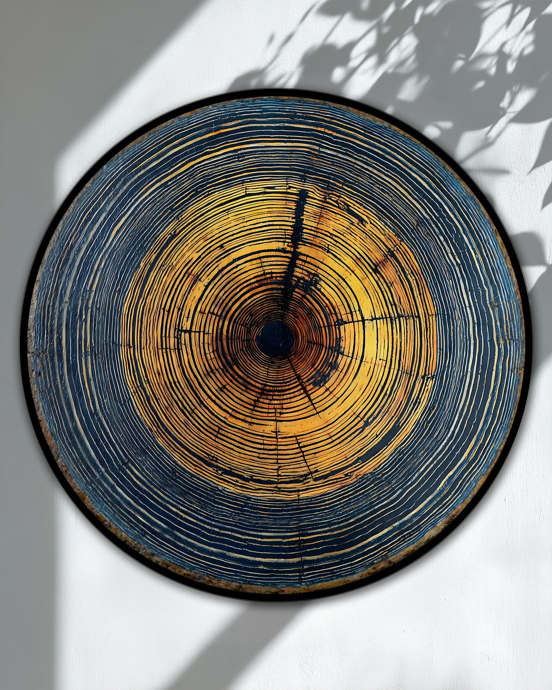 Framed with a sleek black border, this round Golden Tree Rings Abstract Print on hanging canvas presents a gallery-wrapped edge adding depth.