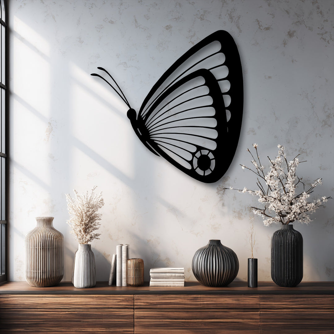 The organic forms of a graceful butterfly metal art for wall are complemented by natural dried botanicals in fluted vases.