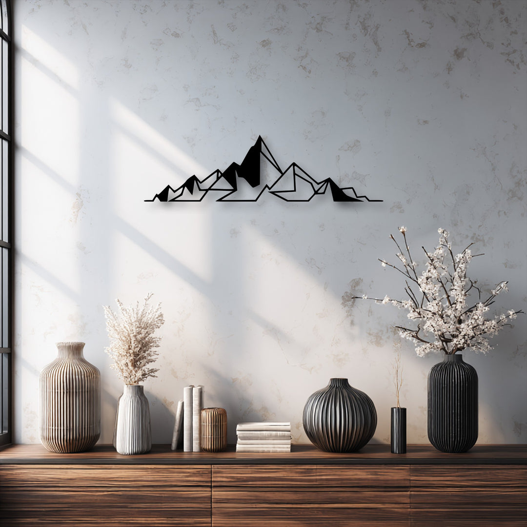 The soft transition of colors from sunlit white to shadowed grey on the textured wall beautifully frames the black geometric metal art for wall.