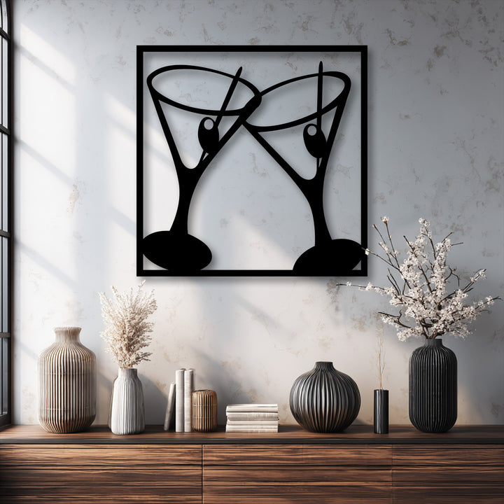 The decorative metal art piece captures the dynamic moment of two cocktail glasses clinking in a modern bar setting.