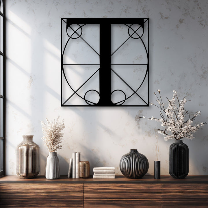 The stark color contrast of the black geometric letter T metal artwork against the bright, textured wall creates a captivating focal point.