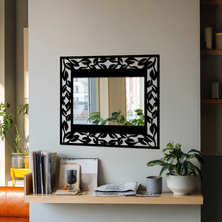 Organic, stylized leaves form a decorative border around this framed wall mirror, embodying an elegant botanical design in metal.