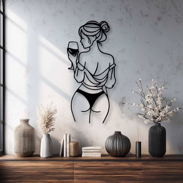 Visual rhythm emphasizes the sleek lines of the wine lady metal artwork, gracefully contrasting with textured wall and ribbed vases.