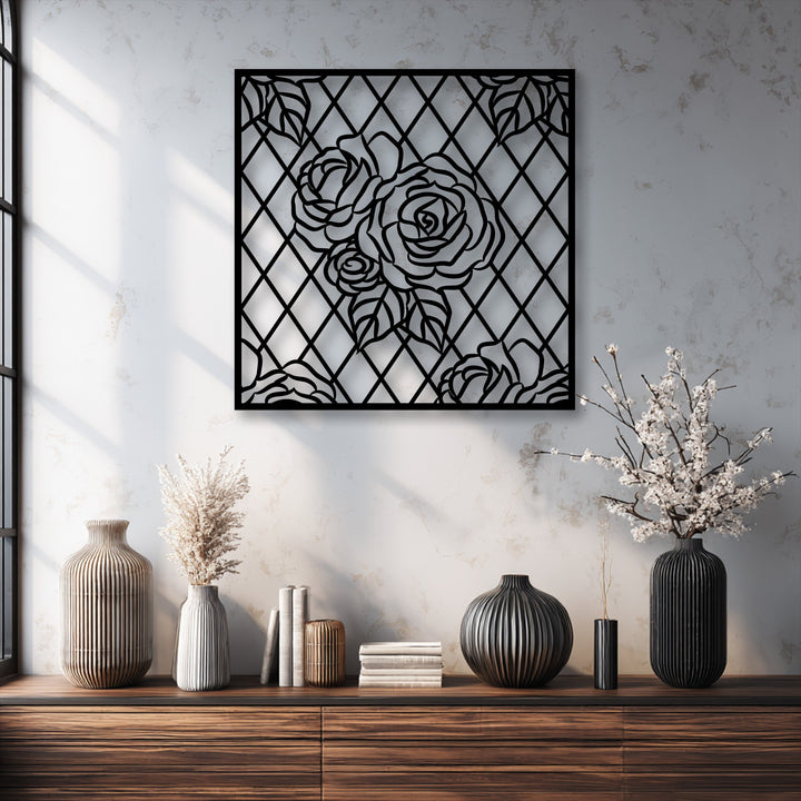 The intricate black silhouette of a rose lattice decorative metal art piece commands attention above a dark console table.