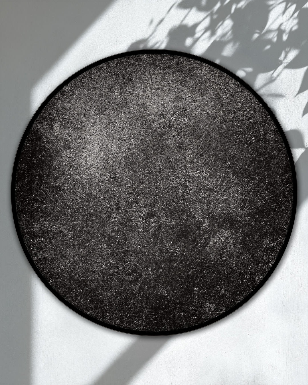 Negative space highlights the round canvas art prints, emphasizing its dark textured, minimal design and modern black wall art aesthetic.