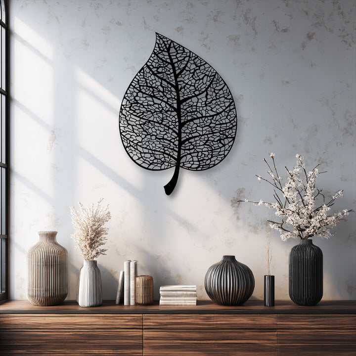 The realistic detail of the intricate vein pattern in this decorative metal art leaf silhouette is stunning against the textured wall.