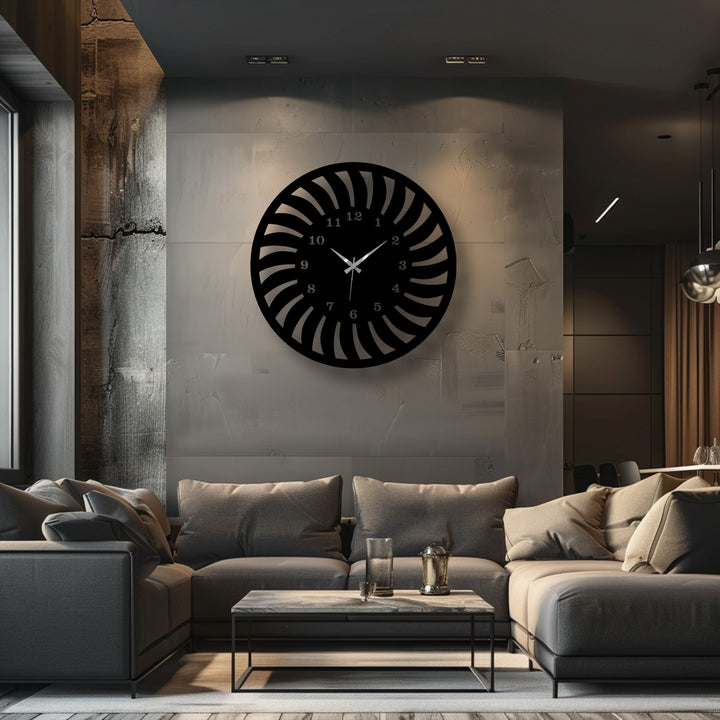 A circular black metal clock with a unique radial spiral pattern forms a piece of unique metal wall art.