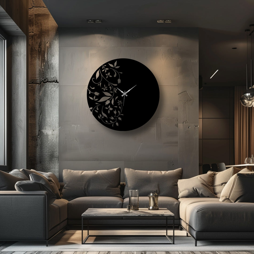 Round, horizontally-oriented metal artwork wall clock presents a striking floral design with delicate leaves adorning the left side.