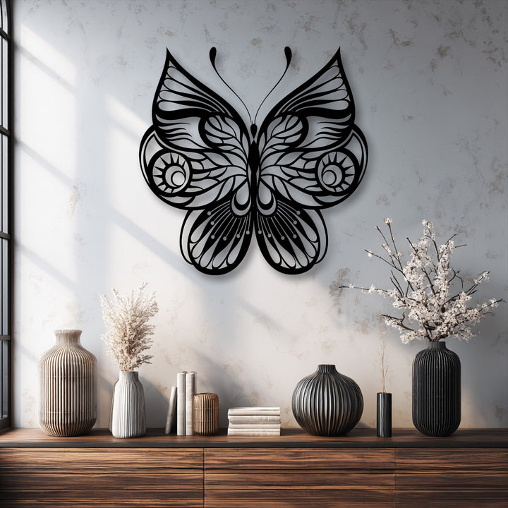 Horizontally oriented and intricately shaped, this ornate butterfly metal artwork features elegant, symmetrical wings with delicate flowing lines.