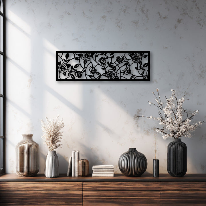 The realistic detail of the black metal wall decor showcases an elegant rose garden floral vine panel, casting intricate shadows.