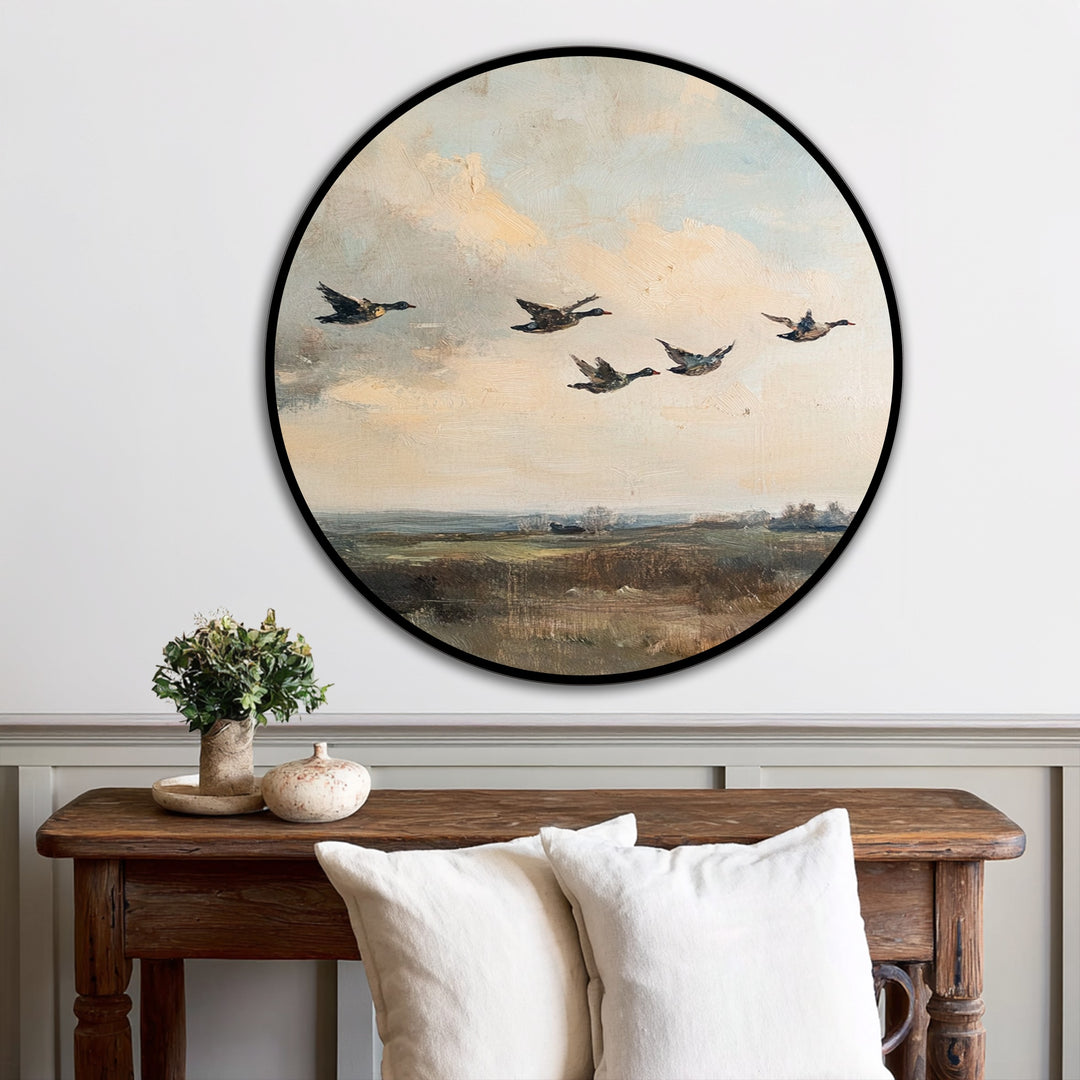 Vast negative space surrounds the circular vintage oil painting artwork of ducks in flight, enhancing the painting's rural landscape depiction.