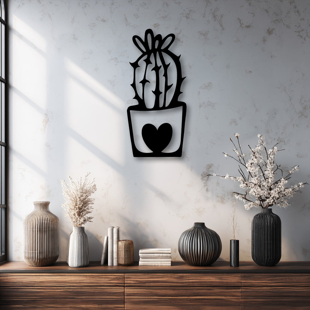 The wall's rough surface texture highlights the sleek black unique metal wall art featuring a cute cactus in a heart pot.