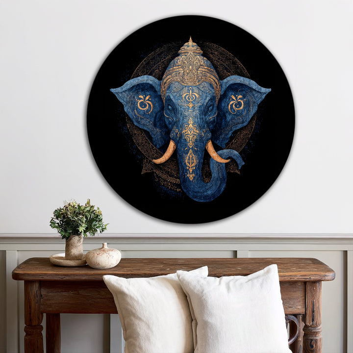 Softly textured linen throw pillows complement the divine indigo majesty, a round sacred elephant oil painting decoration displaying rich gold details.
