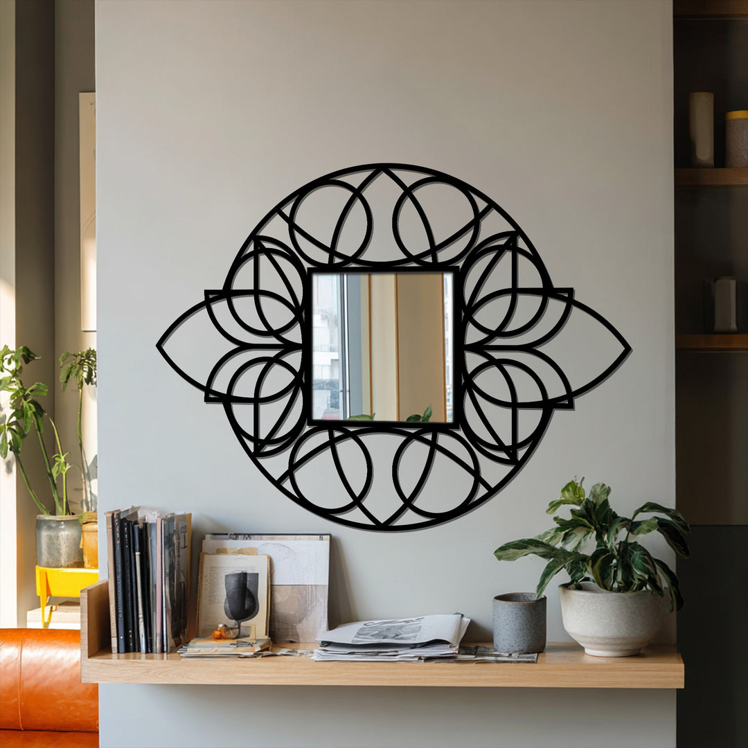 Light and shadow play across the geometric floral details of this black metal frame, giving this modern mirror a captivating, textured metal artwork appearance.