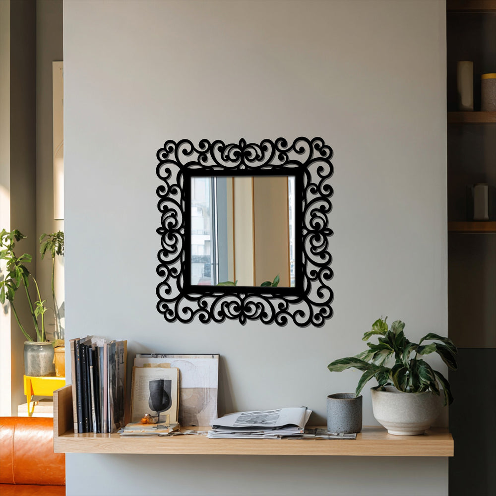 High color contrast highlights the ornate scrollwork of the black metal frame in this decorative modern mirror metal wall decor, mounted on a light wall.