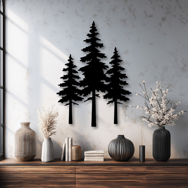 Negative space highlights the striking silhouettes of three pine trees crafted as decorative metal art, casting deep shadows on a bright textured wall.