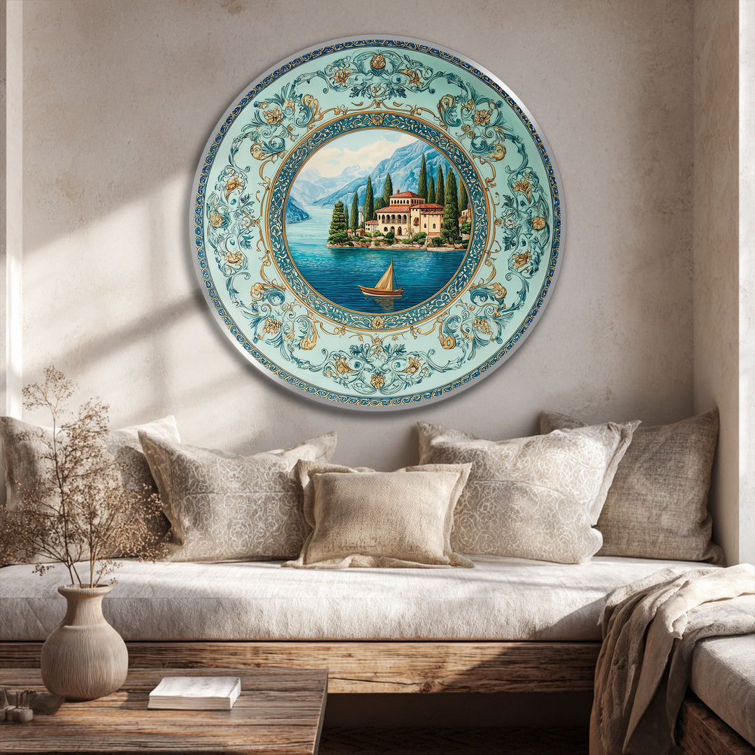 Brightest areas highlight the intricate details of the Mediterranean villa landscape round oil painting art piece depicting a serene turquoise lake and ornate, decorative border.