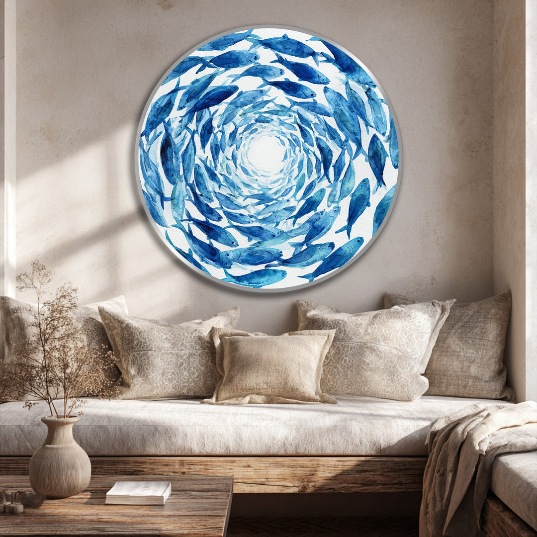 At the focal point, the blue spiral school of fish creates a mesmerizing effect in this round oil painting artwork displayed on a wooden surface.