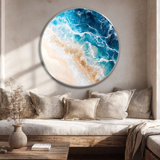 Negative space highlights the turquoise ocean in these round oil painting art prints, contrasting with the surrounding muted pillows and wooden furniture.