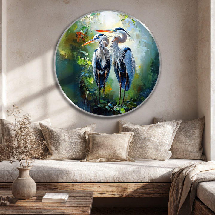Subtle light and shadow interplay accentuate the elegant heron pair in this oil painting art piece, lending depth to the round canvas with its lush green tones.
