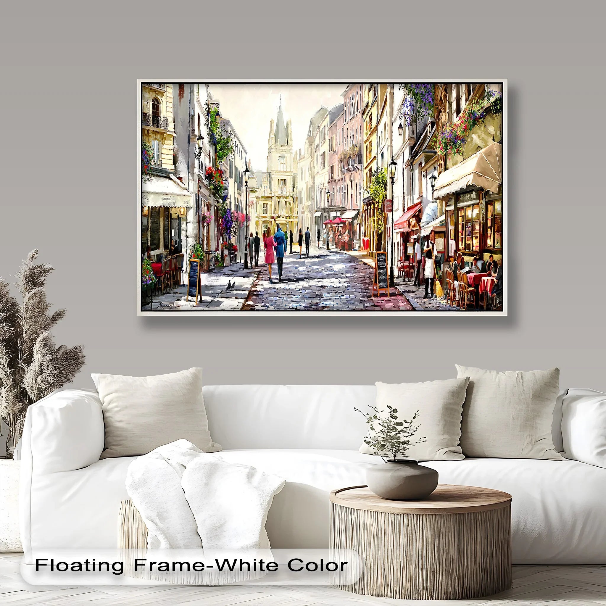 A framed wall art featuring a charming European street with cobblestone paths, elegant cafés, and historic architecture, illuminated by soft daylight

