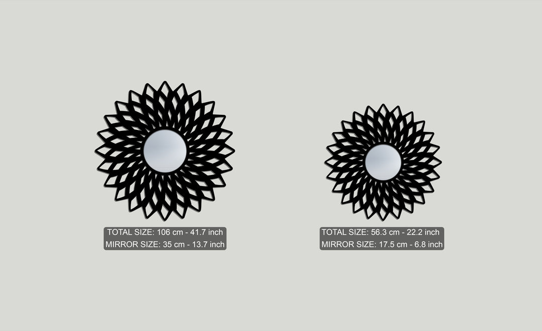 Foreground detail of two intricate black geometric flower floor mirrors, a large and small mirror for wall decor, each with a reflective center.