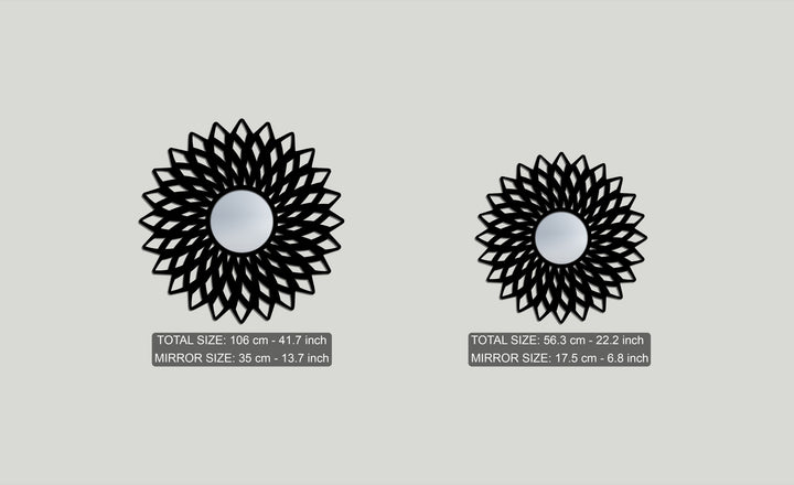 Foreground detail of two intricate black geometric flower floor mirrors, a large and small mirror for wall decor, each with a reflective center.