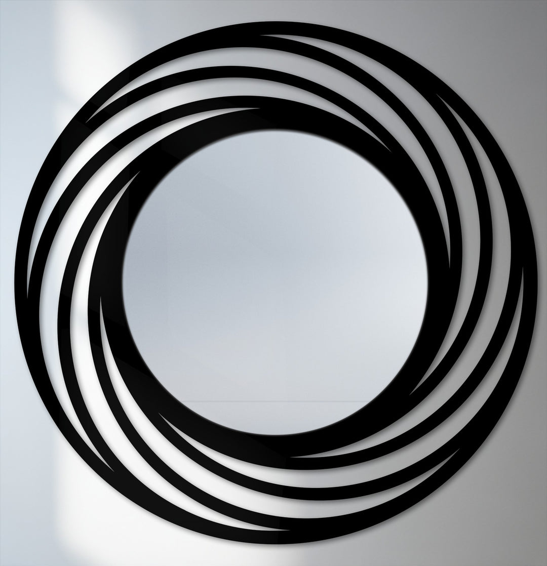 Abstract swirling rings create a captivating metal art for wall, with layered black curves surrounding the modern circle floor mirror's reflective center.