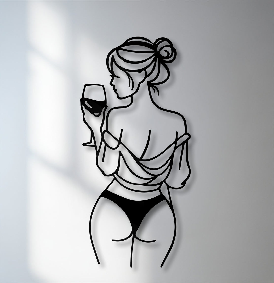 The soft interplay of light and shadow reveals a minimalist line art woman with a wine glass, forming unique metal wall art with striking depth.