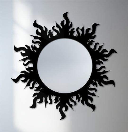 Light and shadow play across the flame crown, framing the round, decorative framed wall mirror, highlighting its modern, asymmetrical design as it hangs on the wall.