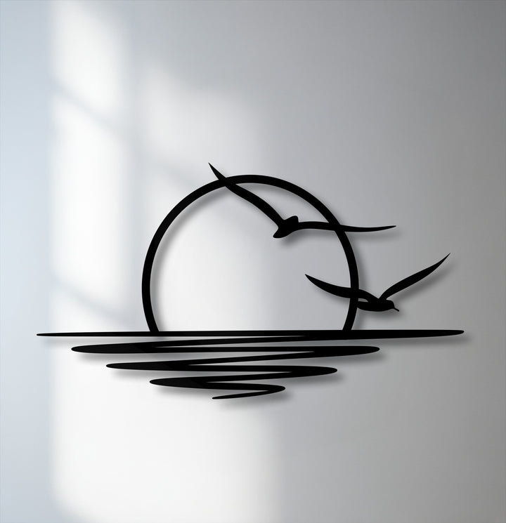 The radiant white background beautifully accentuates the unique metal wall art of a minimalist sunset with two elegant seagulls flying above calm water.