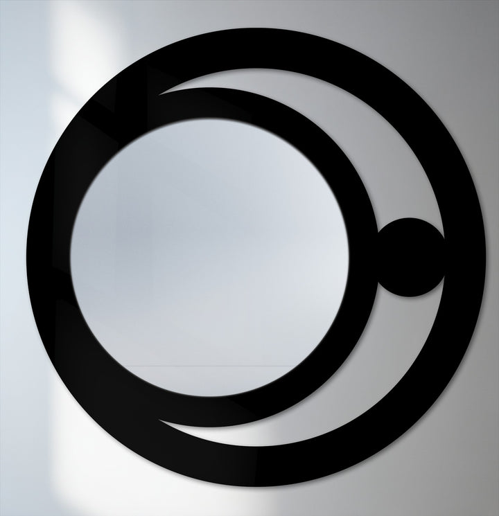 Illustrating the layering effect, a modern mirror features decorative metal art as the crescent orb overlays a solid inner circle and a partial outer ring.