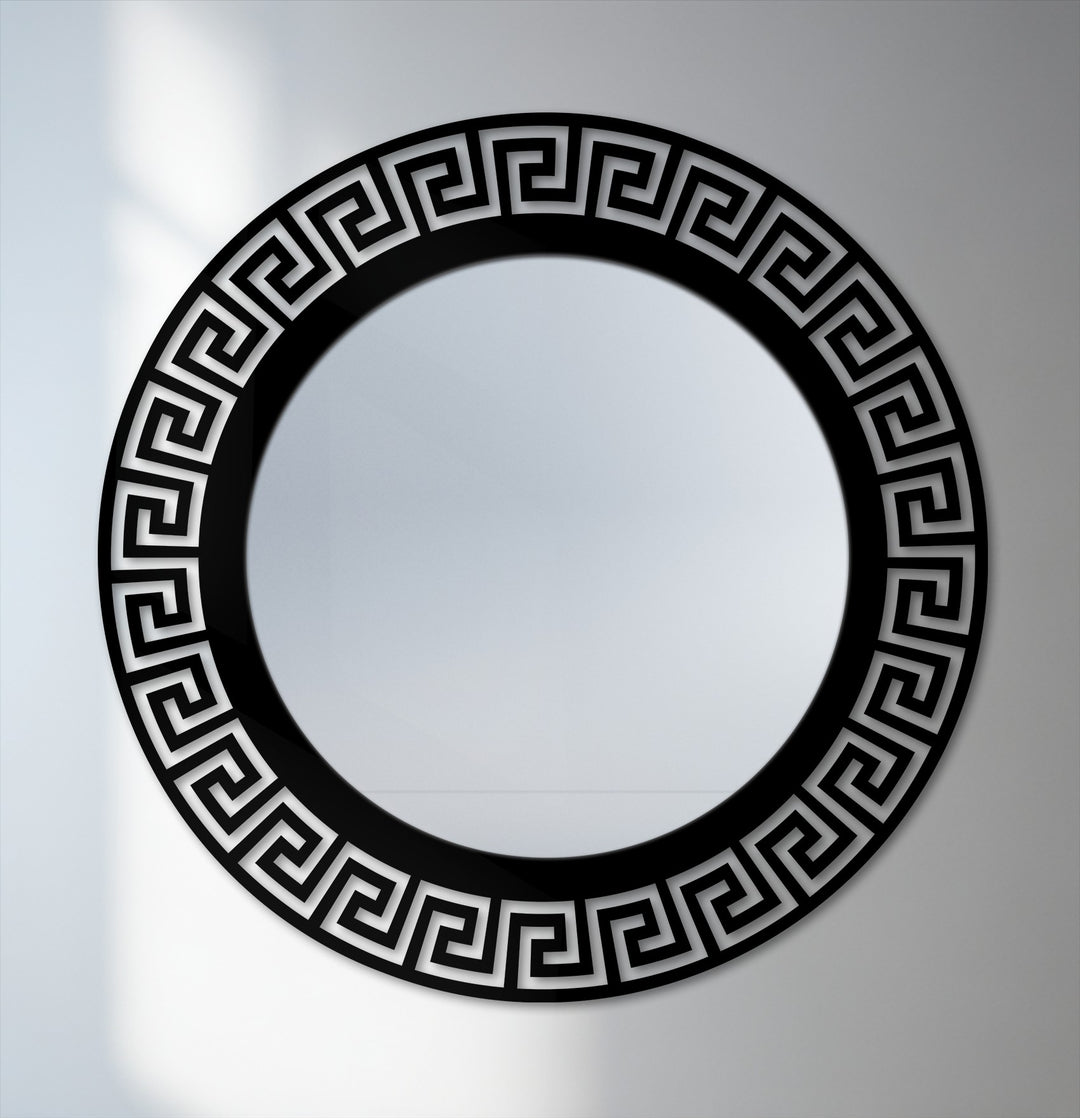 Soft lighting on the neutral background highlights the framed wall mirror featuring a geometric Greek key pattern and black metal decor.