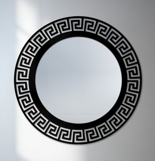 Soft lighting on the neutral background highlights the framed wall mirror featuring a geometric Greek key pattern and black metal decor.
