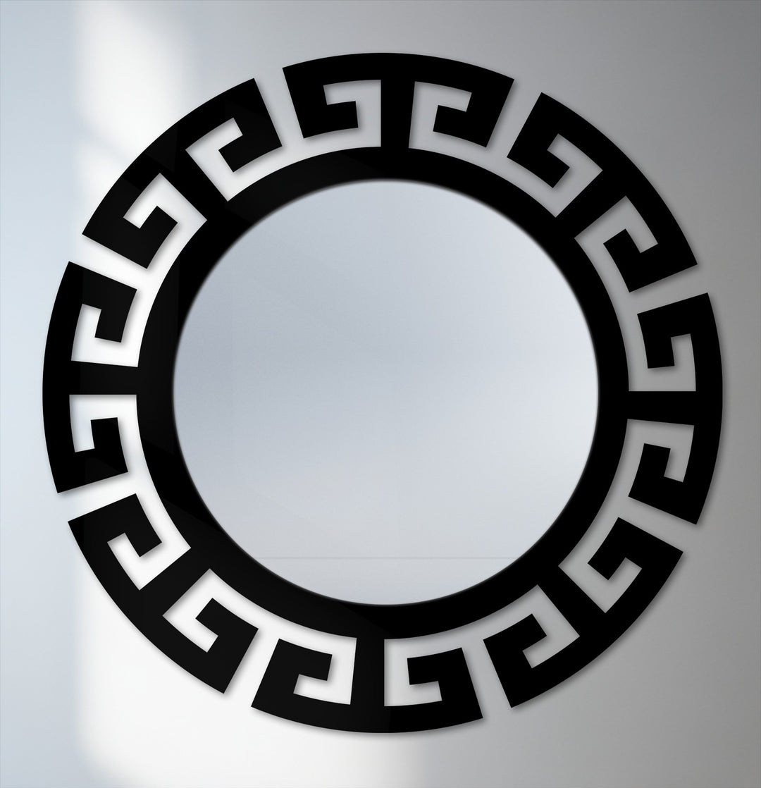 Black metal wall decor composes the segmented Greek key frame around this round floor mirror, bringing a modern, statement design.