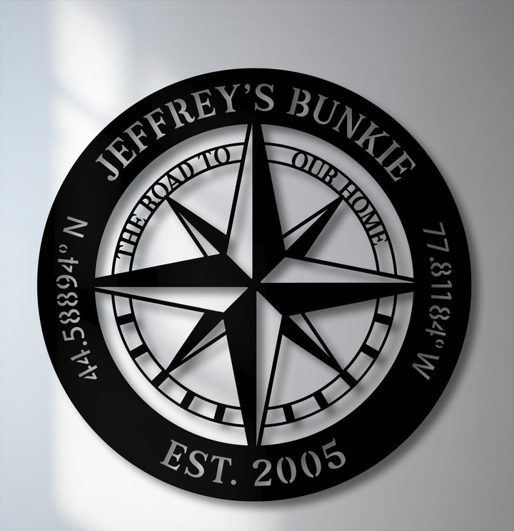 The brilliant white background illuminates the custom name nautical unique metal wall art, emphasizing the detailed black compass design.
