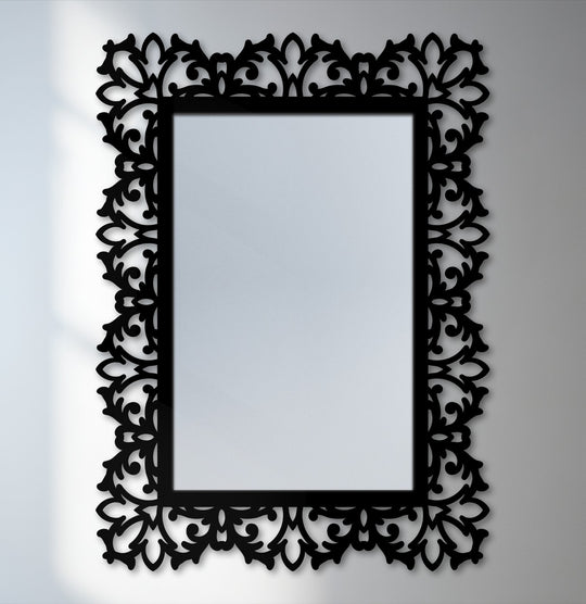 Cool color temperature highlights the black metal frame and botanical scroll details of this elegant, rectangular framed wall mirror.