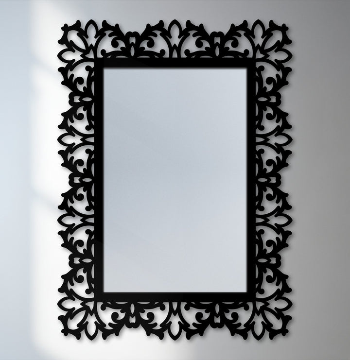 Cool color temperature highlights the black metal frame and botanical scroll details of this elegant, rectangular framed wall mirror.
