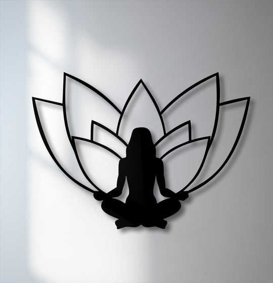 High-quality black metal wall decor featuring a serene lotus meditation silhouette casts elegant shadows on a bright white wall.