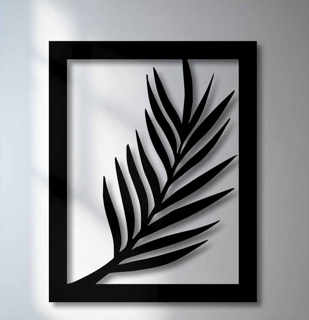 The darkest area showcases a deep black metal wall decor, intricately cut into a minimal palm leaf silhouette within its sharp frame.