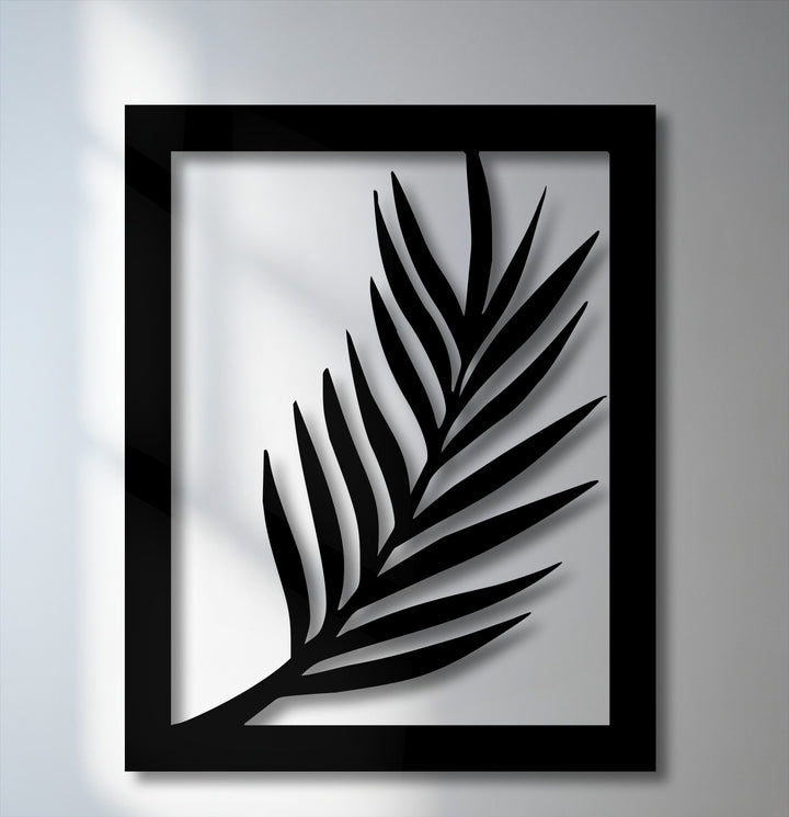 The darkest area showcases a deep black metal wall decor, intricately cut into a minimal palm leaf silhouette within its sharp frame.