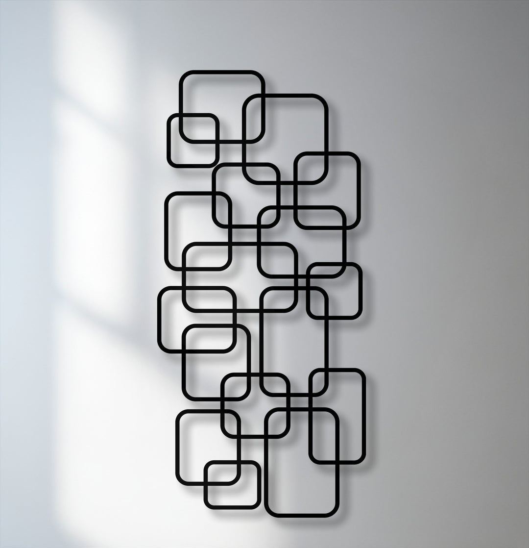 The striking color contrast of black geometric metal art for wall featuring interlocking rounded squares against a light grey background.