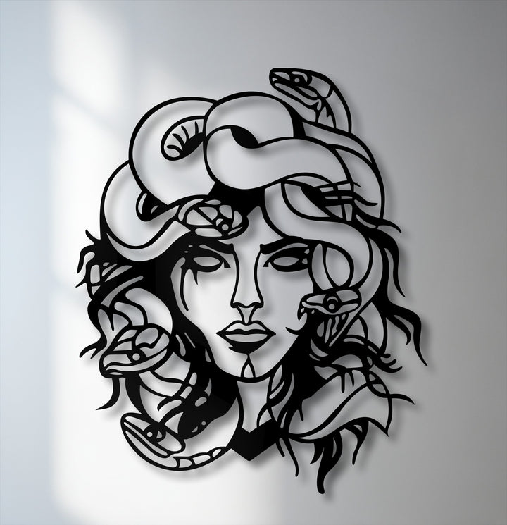 The sleek, matte surface texture of the unique metal wall art featuring Medusa, a mythological snake goddess, casts a sharp shadow against the wall.