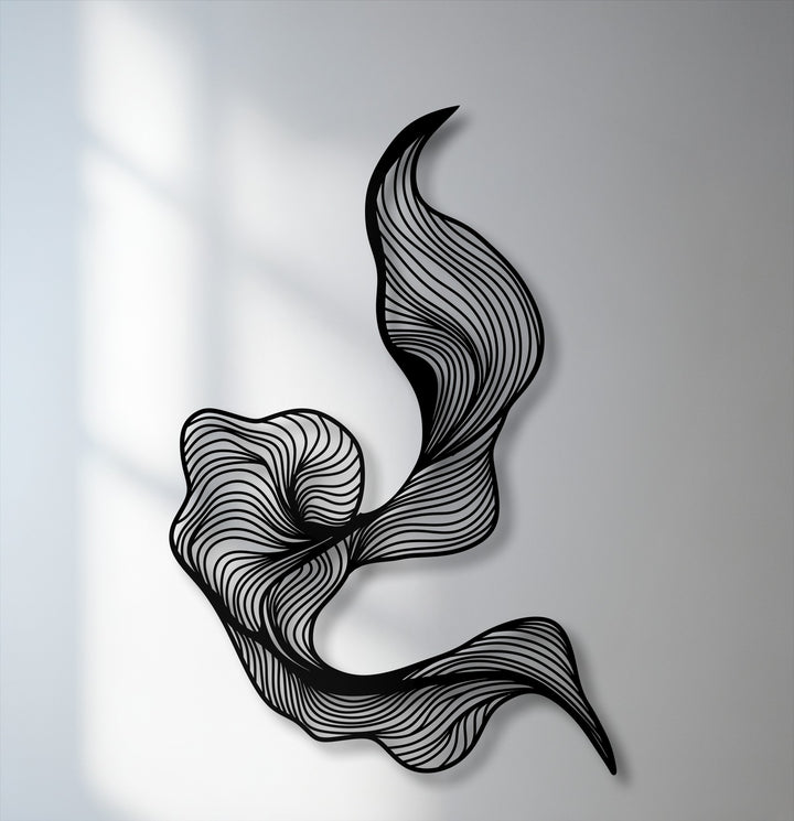 The bold, abstract flow of this metal wall decor features a modern fluid line design, casting soft shadows on a light wall.