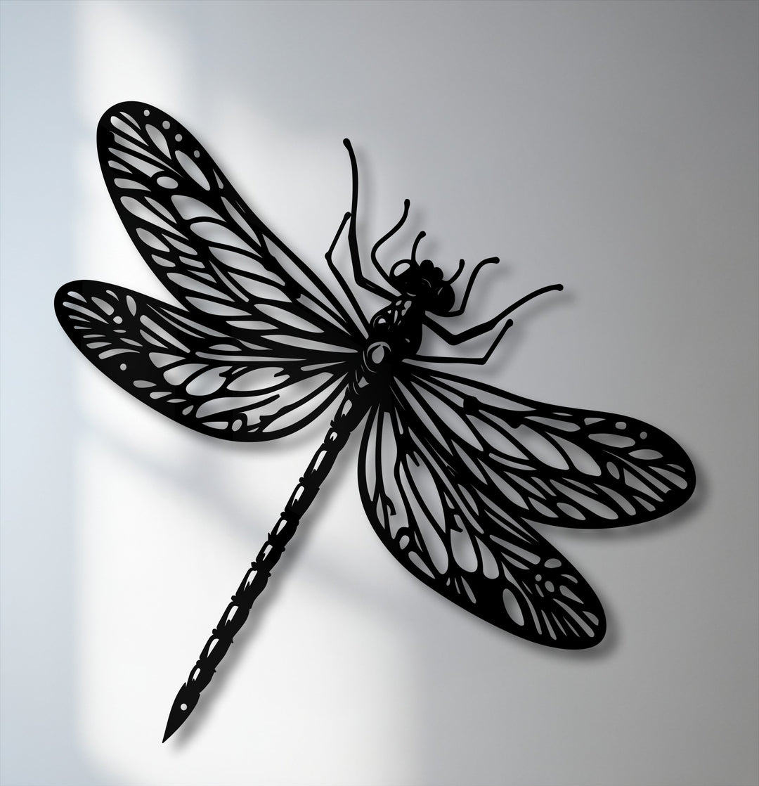 The organic forms of an elegant black dragonfly metal art for wall, with intricate wings casting subtle shadows.