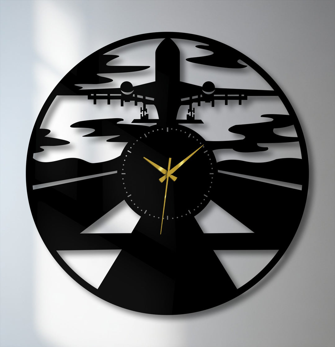 A perfectly circular, intricately designed decorative metal art clock features an airplane silhouette descending onto a runway, oriented for hanging.