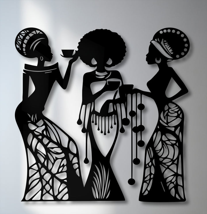 Vertically oriented, slender black silhouettes of three African women with distinct headwear and patterned dresses define this elegant metal artwork.