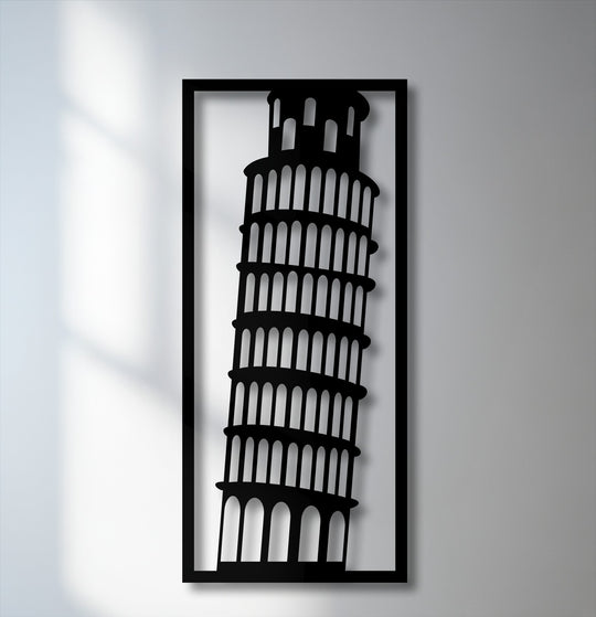 The darkest area reveals a striking black silhouette of the Leaning Tower of Pisa within a rectangular frame, forming a piece of decorative metal art.