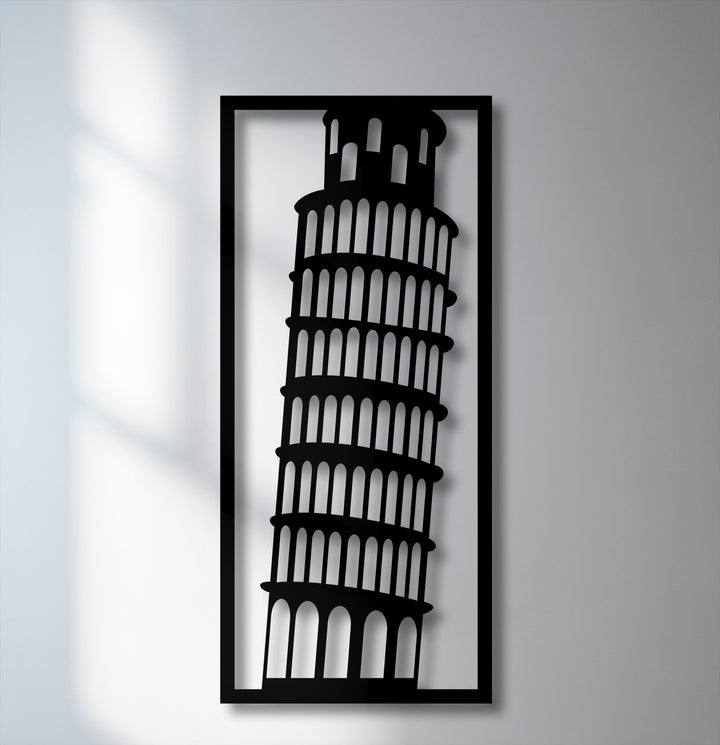 The darkest area reveals a striking black silhouette of the Leaning Tower of Pisa within a rectangular frame, forming a piece of decorative metal art.